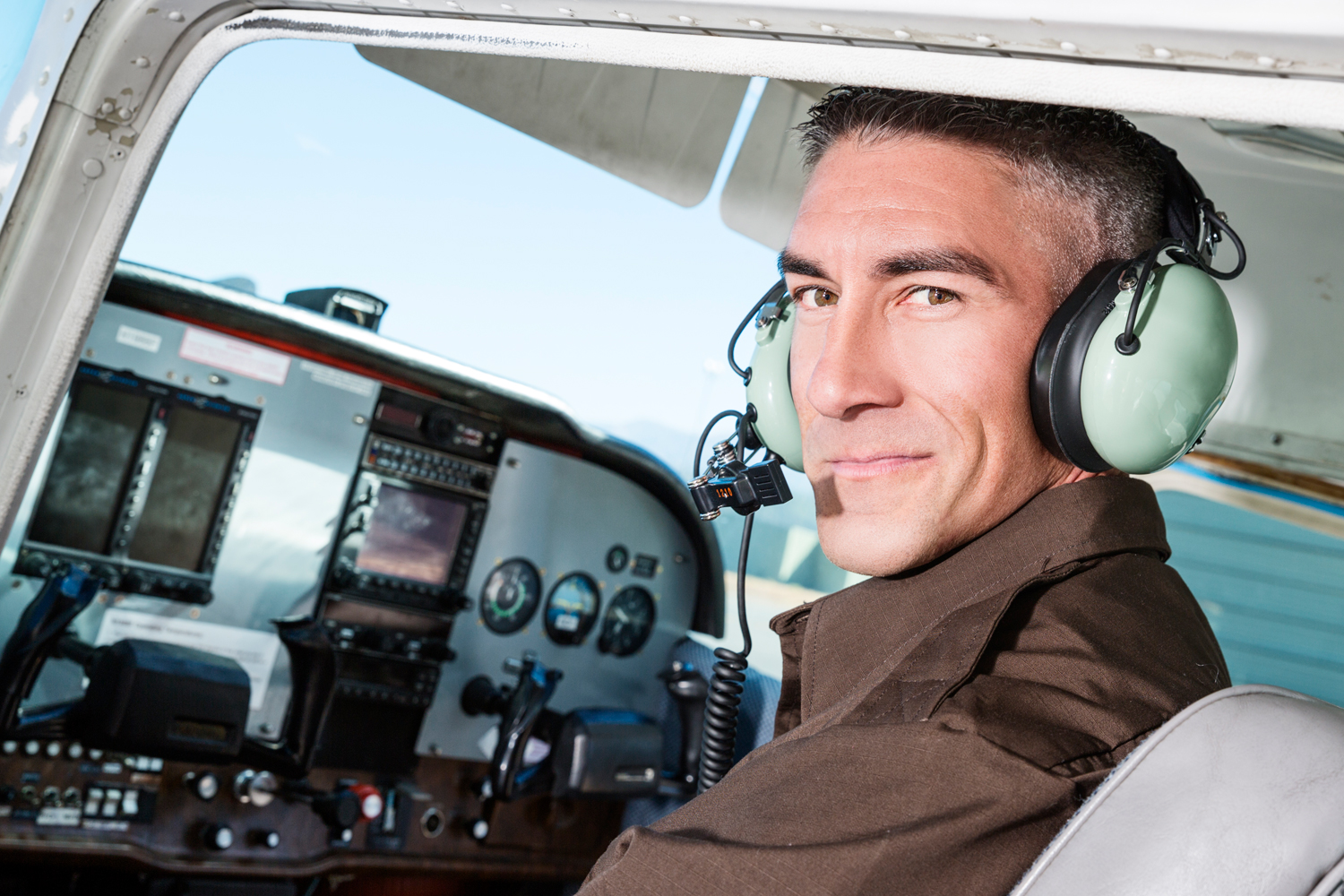 General aviation pilot wearing a headset on the flight deck of an aircraft