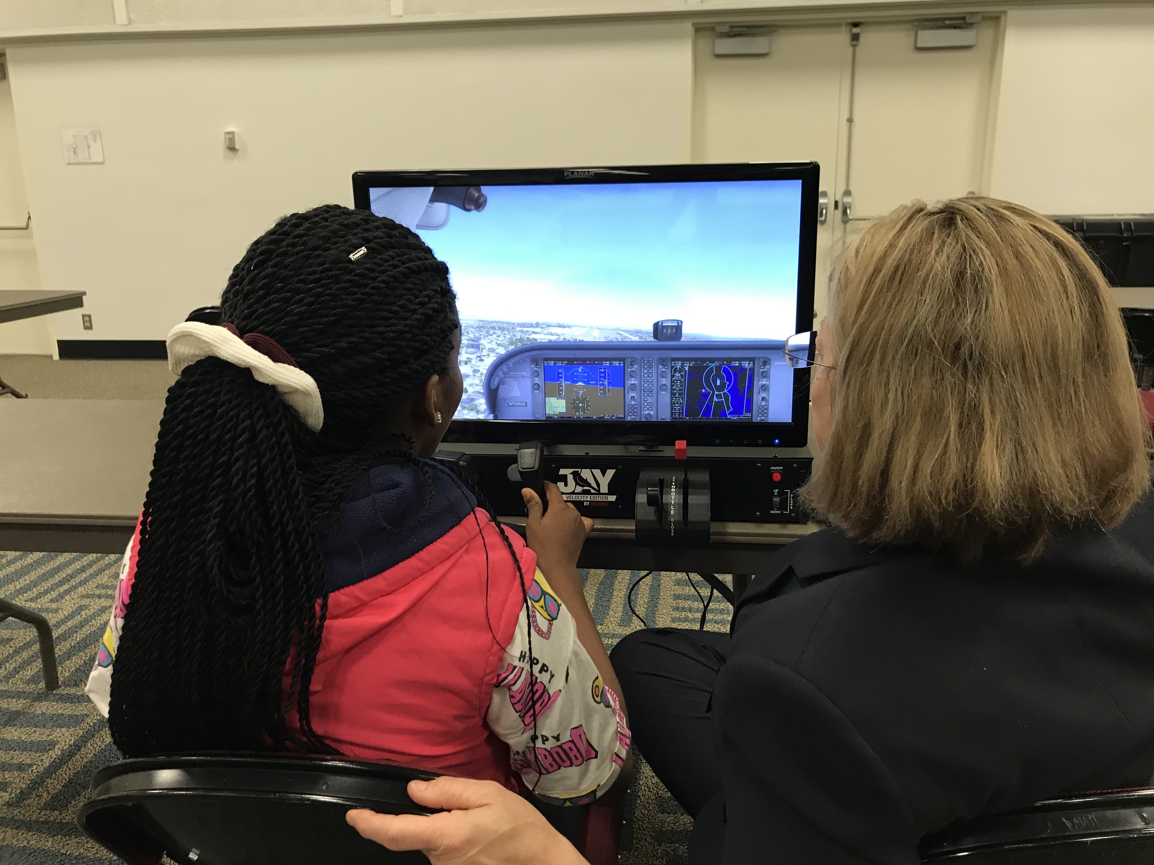 Student and teacher learning with a Redbird Jay Velocity flight simulator